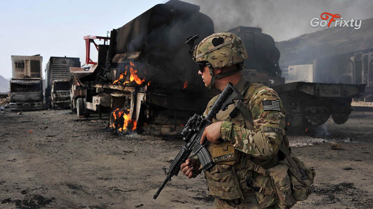 A NATO personnel holding a gun in a battle field